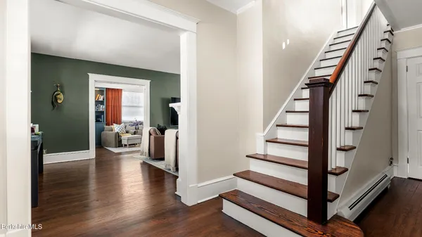 a view of a hallway with wooden floor and staircase