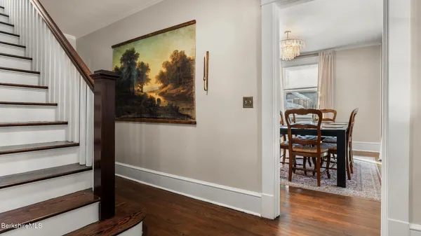 a view of a hallway with wooden floor and a dining room
