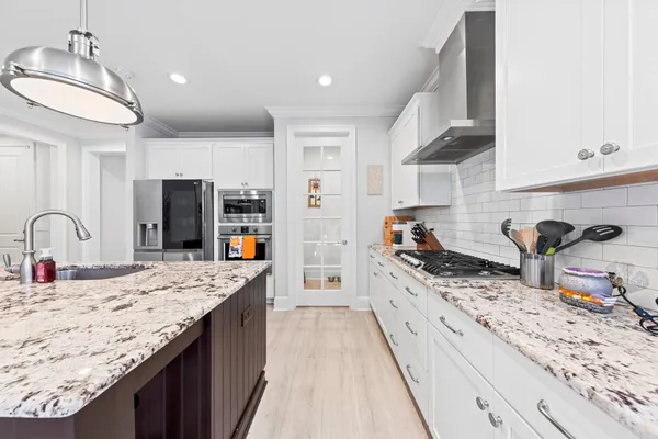 a kitchen with granite countertop a sink stove and refrigerator