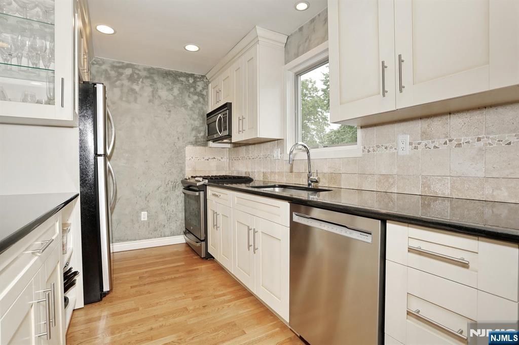 87 Barbara Road Dumont, NJ 07628 - Photo 17 of 48 a kitchen with white cabinets and appliances