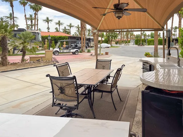 a patio with a table and chairs under an umbrella