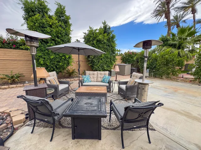 a view of an outdoor sitting area with furniture and umbrella