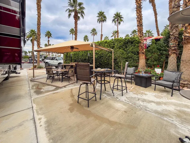 a view of a patio with a table and chairs and potted plants