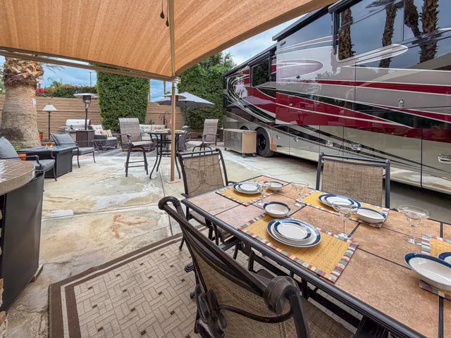a outdoor dining table with chairs and a stove