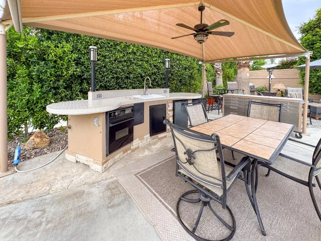 a view of a patio with a table and chairs under an umbrella