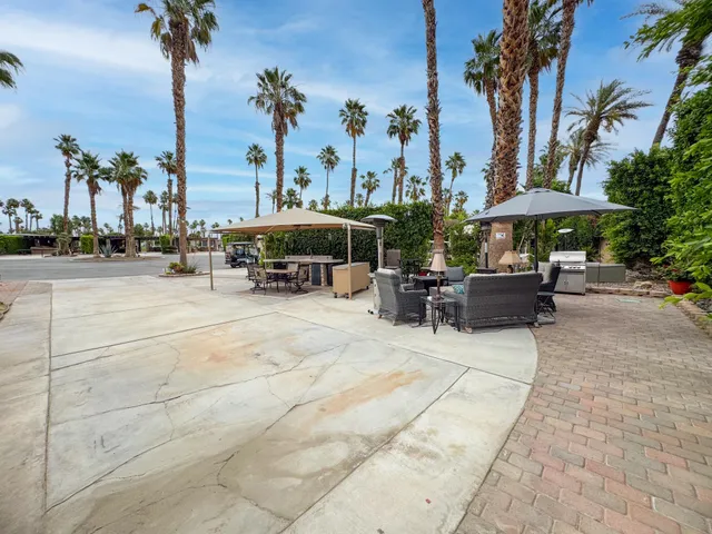a view of a patio with a table and chairs under an umbrella