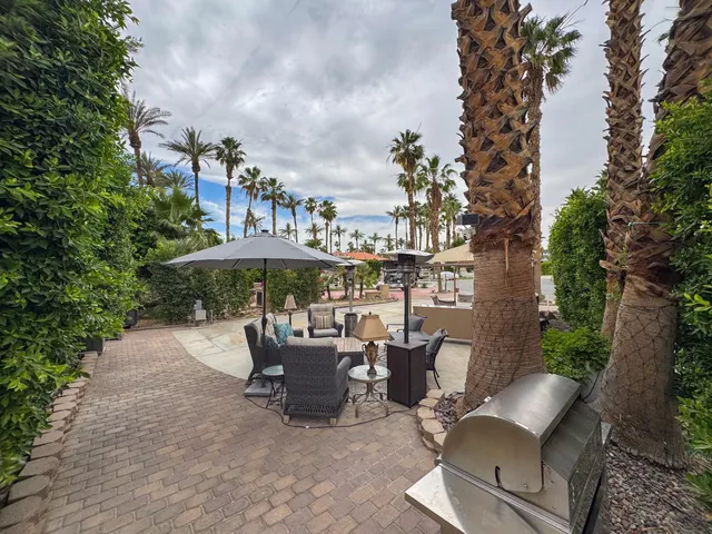 a patio with couches table and chairs and potted plants