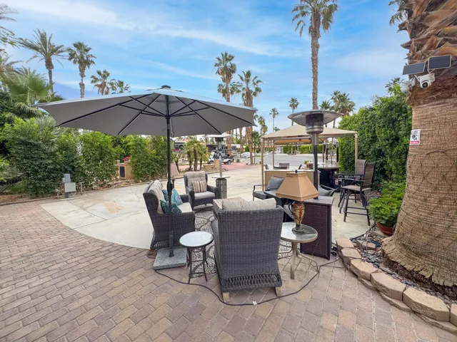 a view of a patio with chairs under an umbrella