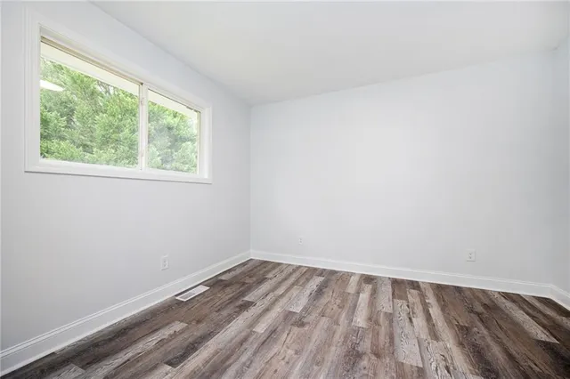 wooden floor in an empty room with a window