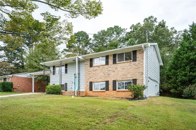 a view of a house with a yard and sitting area