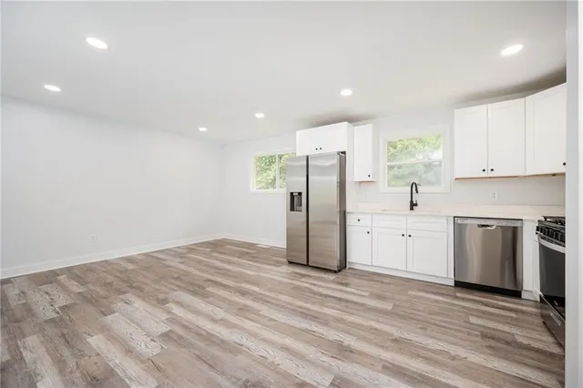 a kitchen with stainless steel appliances a refrigerator and a stove top oven