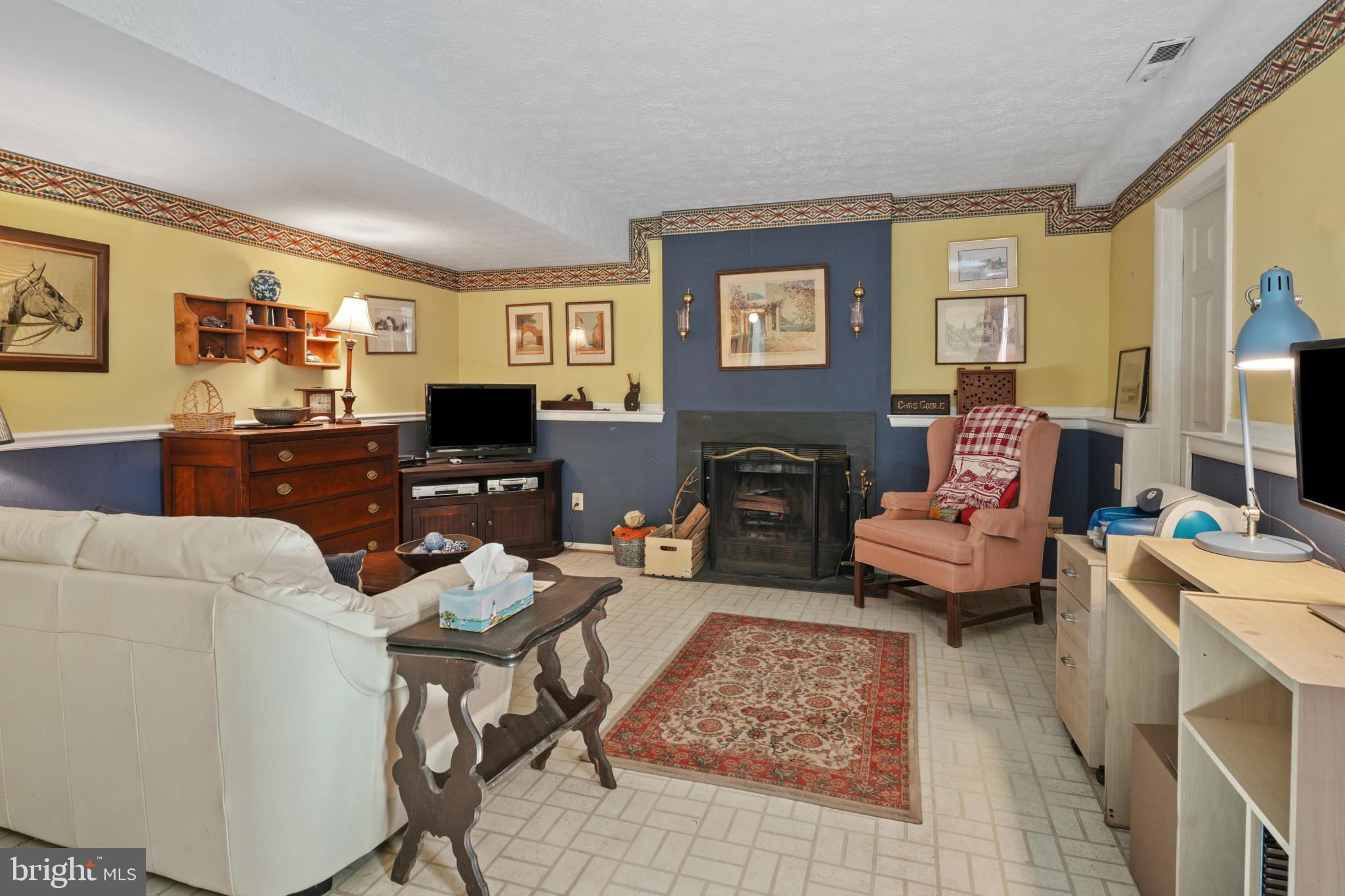12733 Cunninghill Cove Road Middle River, MD 21220 - Photo 14 of 32 a living room with furniture a flat screen tv and a fireplace