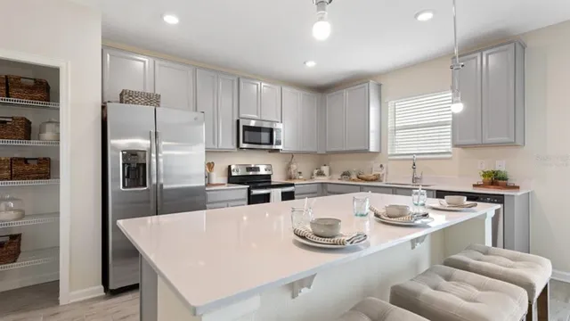 a kitchen with stainless steel appliances granite countertop a sink stove refrigerator and microwave