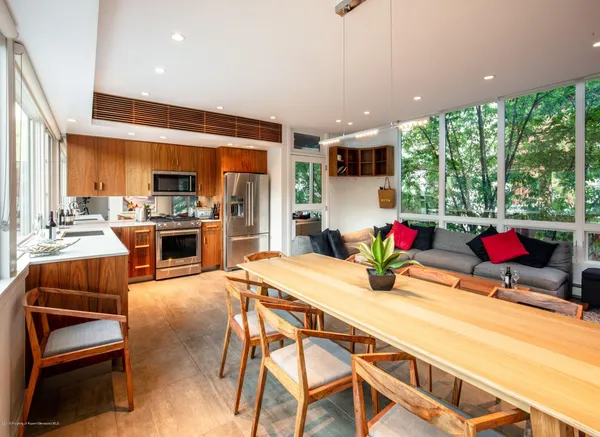 a kitchen with a table chairs stove and kitchen view