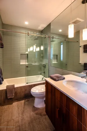 a bathroom with a sink a toilet a mirror and bathtub