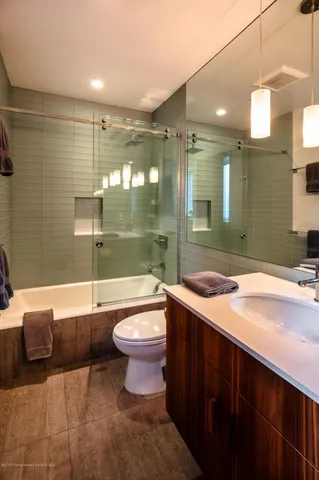 a bathroom with a sink a toilet a mirror and bathtub