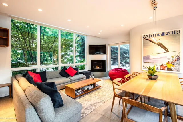a living room with furniture fireplace and a large window