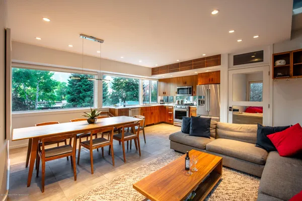 a dining room with furniture a rug and a large window
