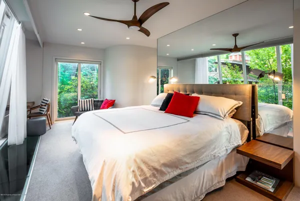 a large bed sitting in a bedroom next to a window