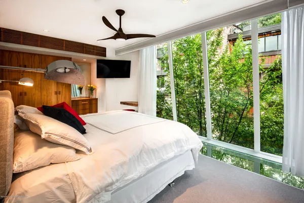 a bed room with a bed and a flat tv screen