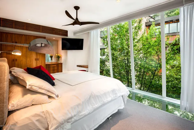 a bed room with a bed and a flat tv screen