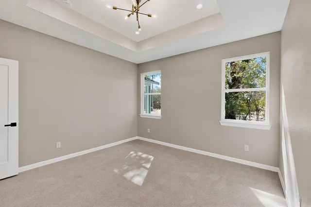 en empty room with windows and ceiling fan