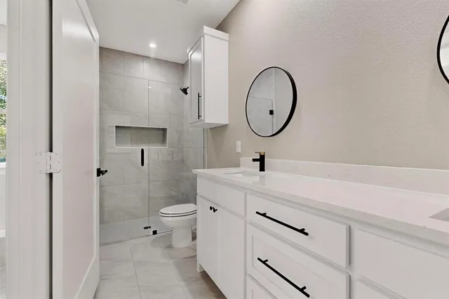 a bathroom with a double vanity sink mirror and toilet