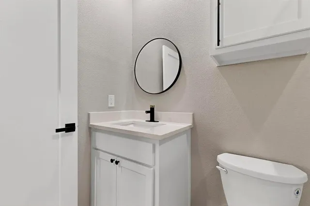 a bathroom with a toilet a sink and a mirror
