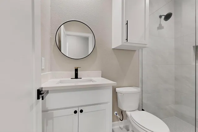 a bathroom with a toilet a sink and mirror