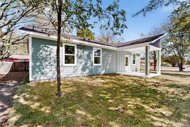 a view of a house with a tree in the yard