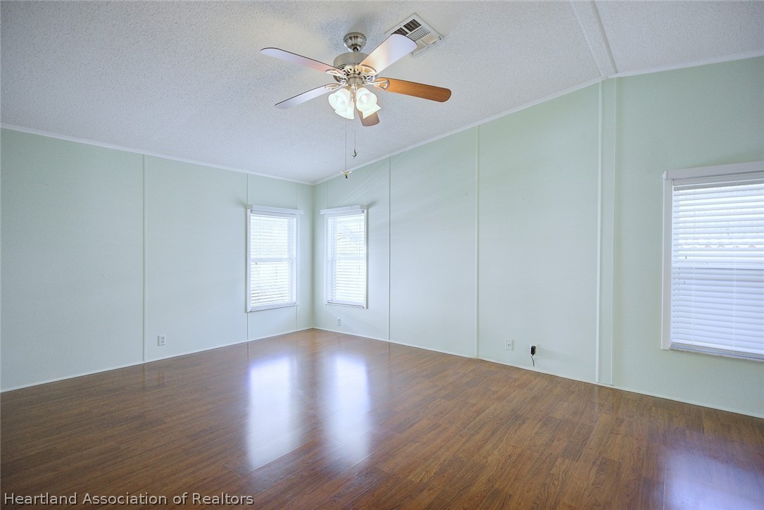 2702 Rodney Street Sebring, FL 33872 - Photo 16 of 33 an empty room with wooden floor and windows