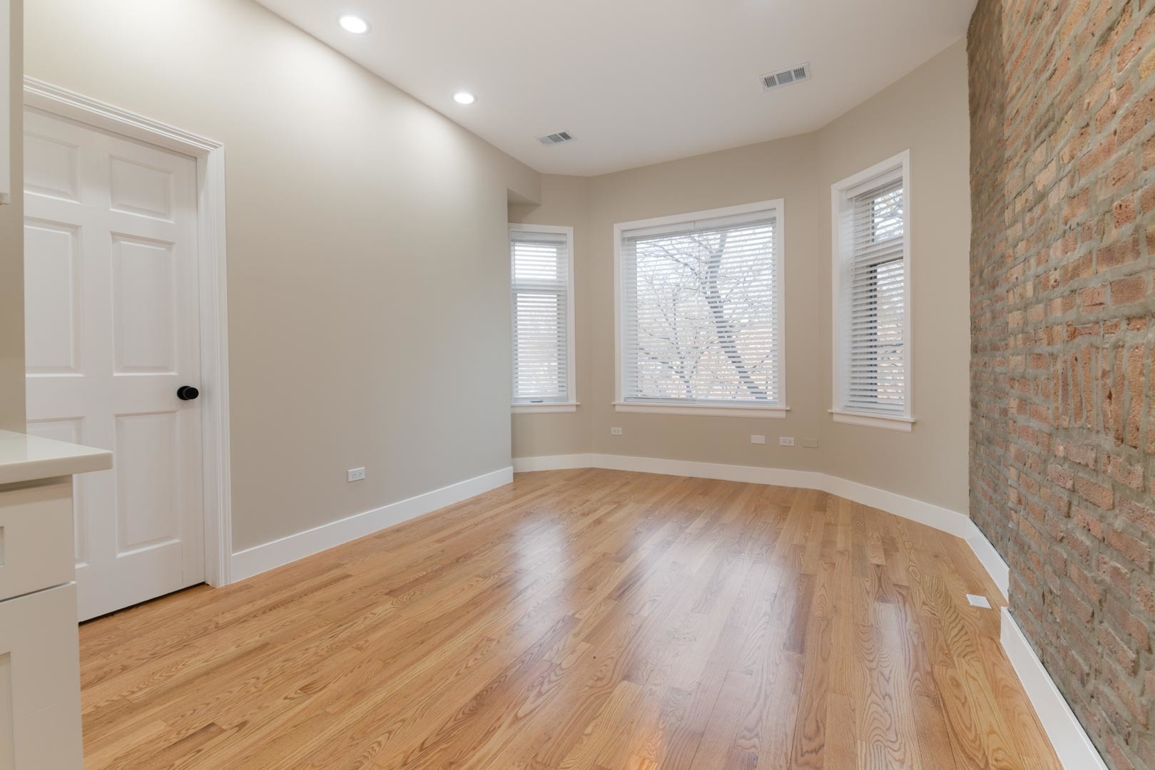 1303 West Flournoy Street, Unit 2F Chicago, IL 60607 - Photo 2 of 16 a view of an empty room with wooden floor and a window