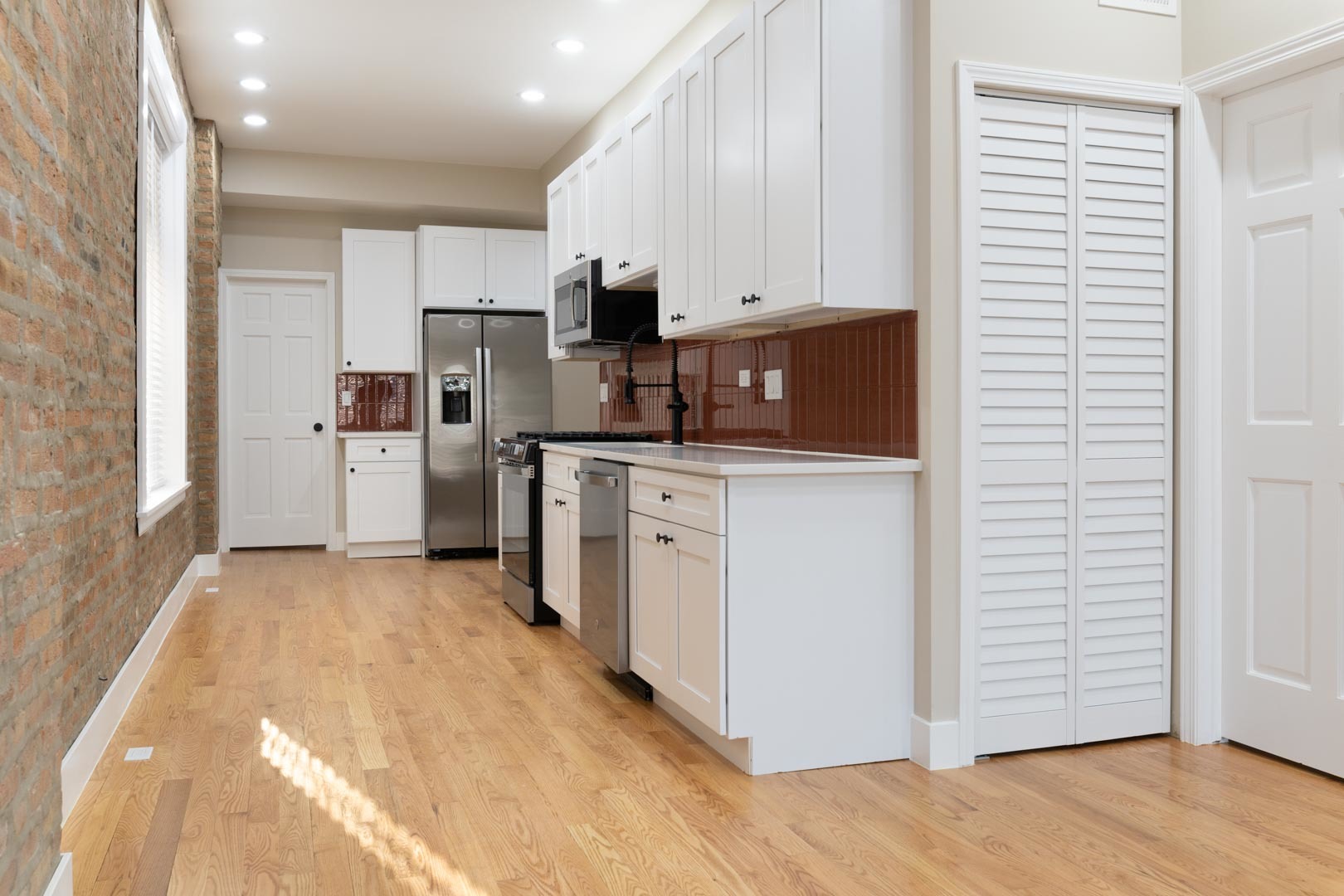 1303 West Flournoy Street, Unit 2F Chicago, IL 60607 - Photo 6 of 16 a kitchen with white cabinets and white appliances