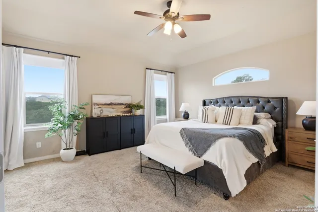 a spacious bedroom with a bed and a cabinets