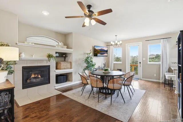 a dining room with furniture a fireplace and wooden floor