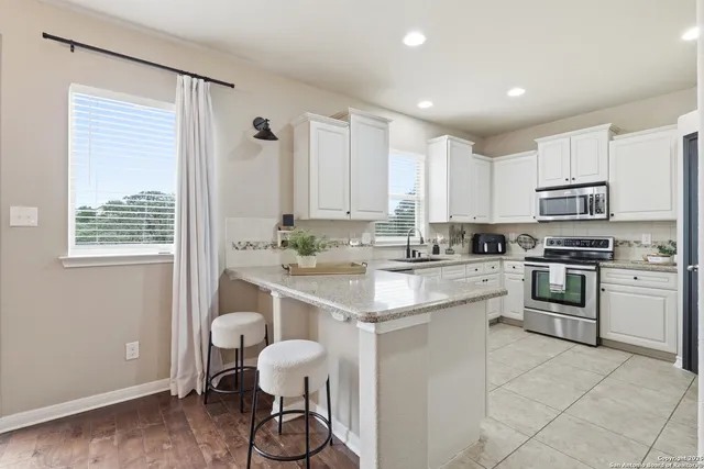 a kitchen with a sink stove and white cabinets