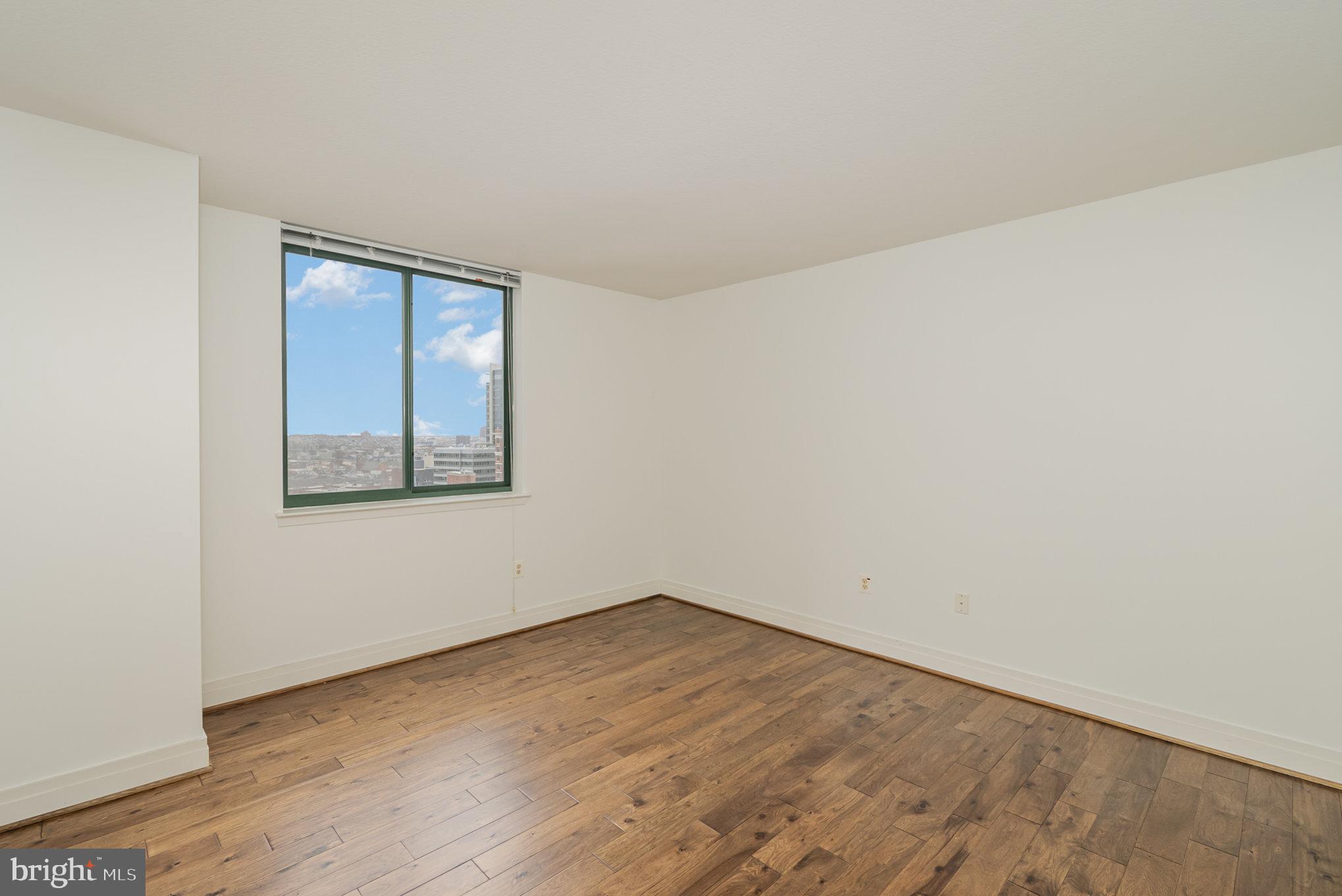414 Water Street, Unit 1512 Baltimore, MD 21202 - Photo 11 of 28 an empty room with wooden floor and windows