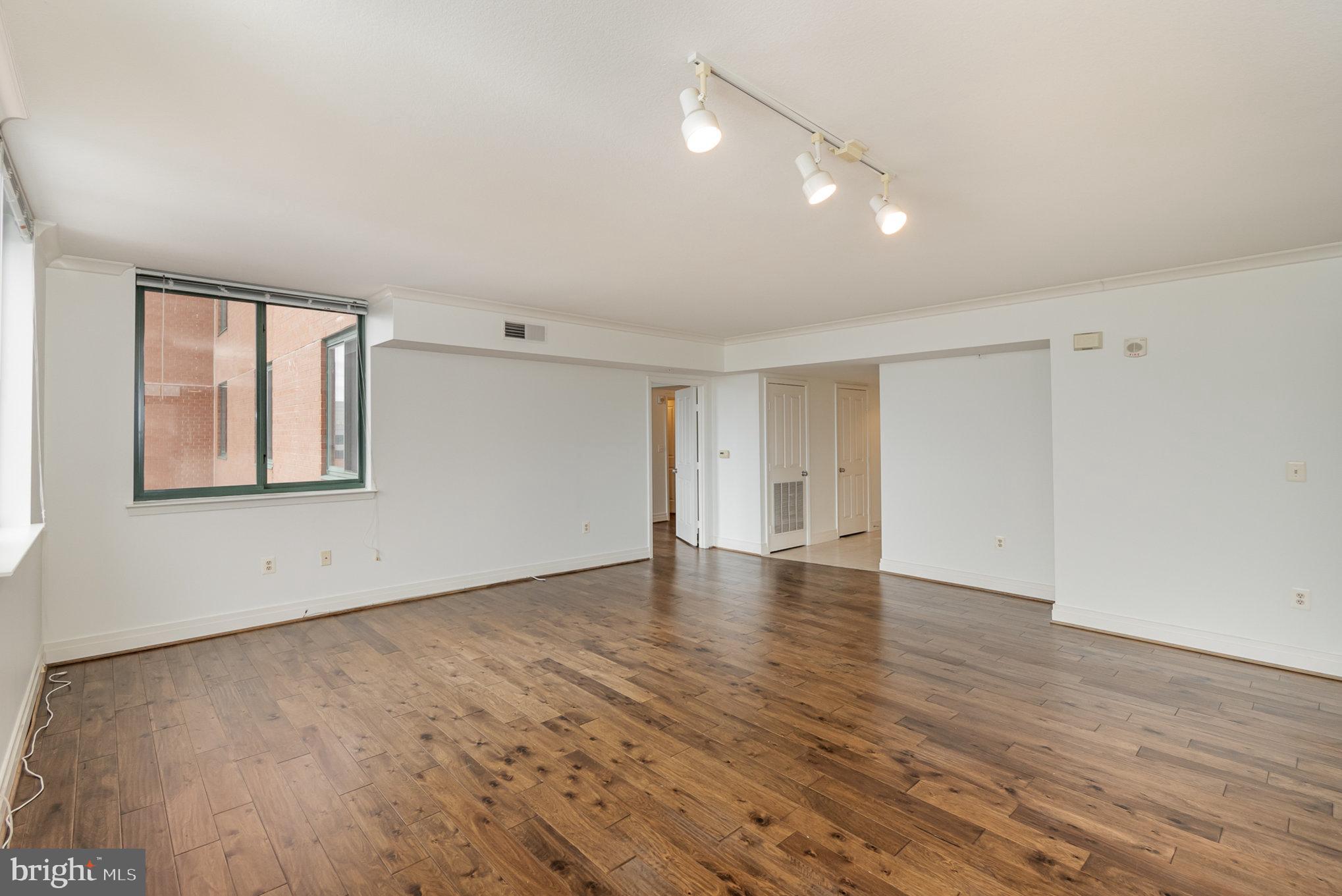 414 Water Street, Unit 1512 Baltimore, MD 21202 - Photo 7 of 28 a view of an empty room with wooden floor and a window