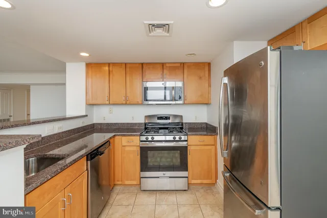 a kitchen with granite countertop a stove top oven and cabinets