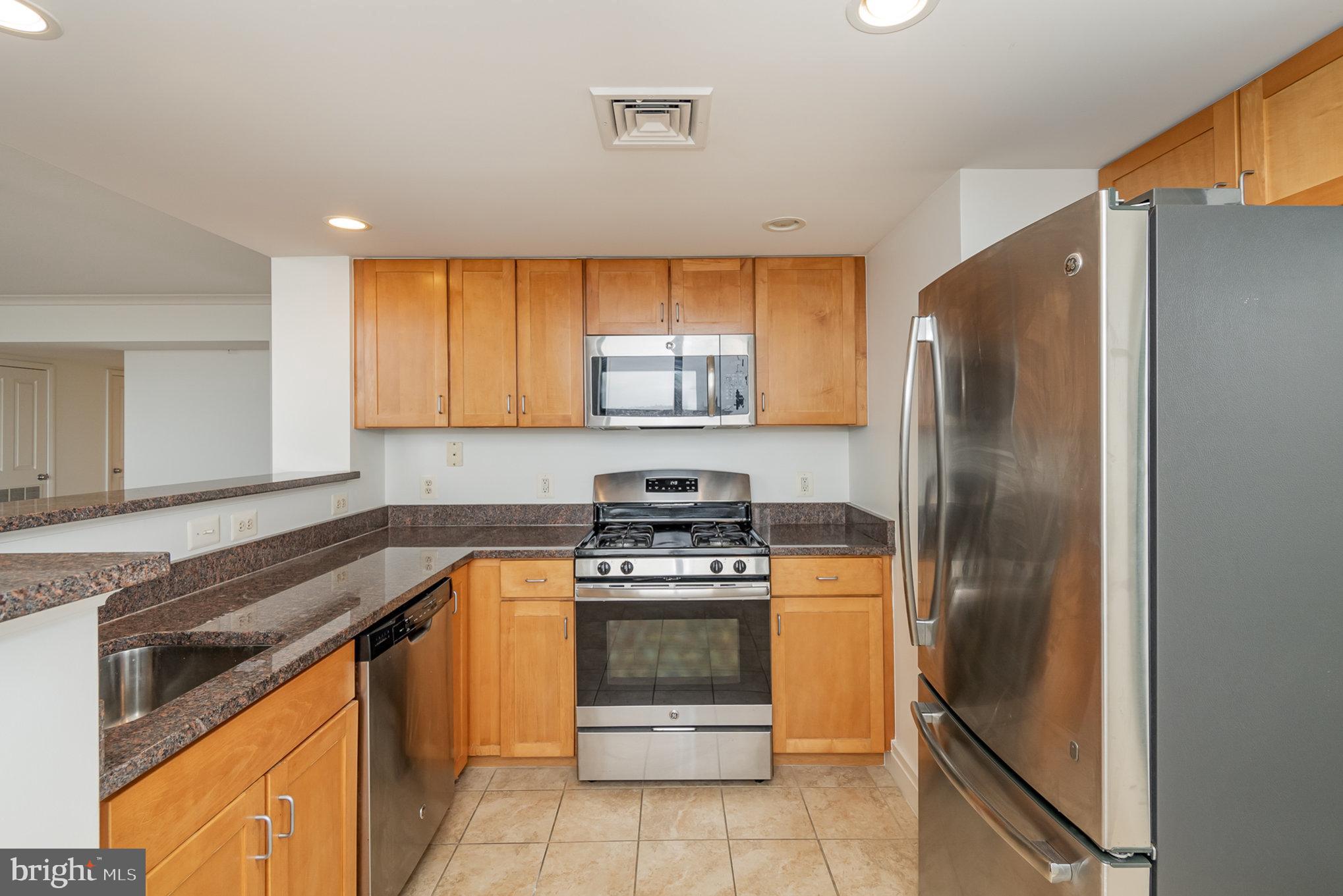 414 Water Street, Unit 1512 Baltimore, MD 21202 - Photo 9 of 28 a kitchen with a stove a refrigerator and cabinets