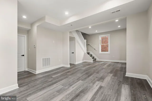 a view of empty room with wooden floor and window