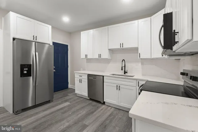 a kitchen with stainless steel appliances a refrigerator sink and cabinets