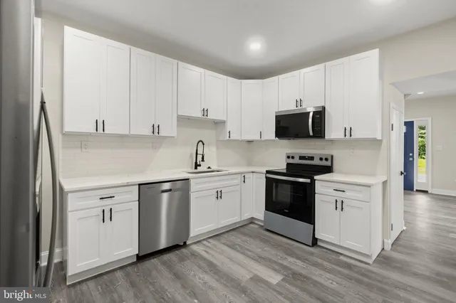 a kitchen with granite countertop white cabinets and white appliances