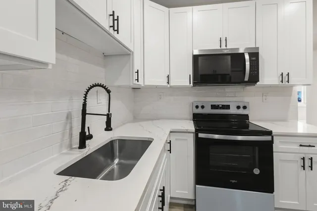 a kitchen with stainless steel appliances a stove a sink and a microwave