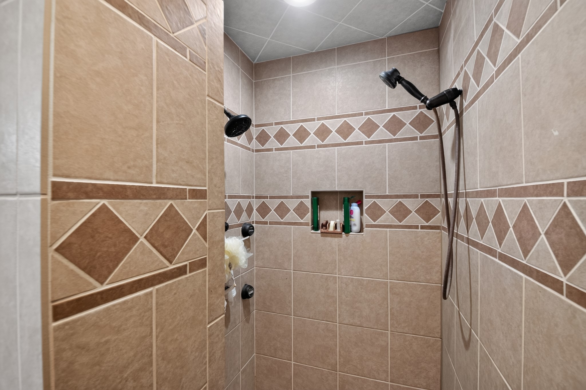 1950 Country Club Road Brenham, TX 77833 - Photo 22 of 39 Step into this shower with intricate tile work and convenient recessed storage.