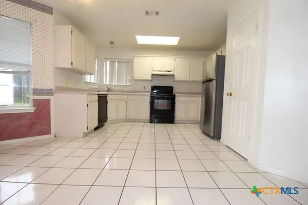 a kitchen with a sink a stove cabinets and counter space