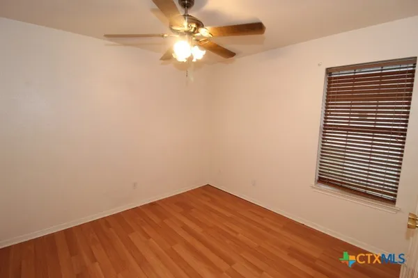 a view of a small space with wooden floor and a ceiling fan