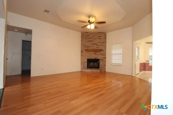 a view of an empty room with a fireplace and a window