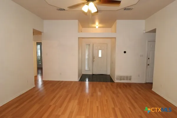 a view of empty room with wooden floor