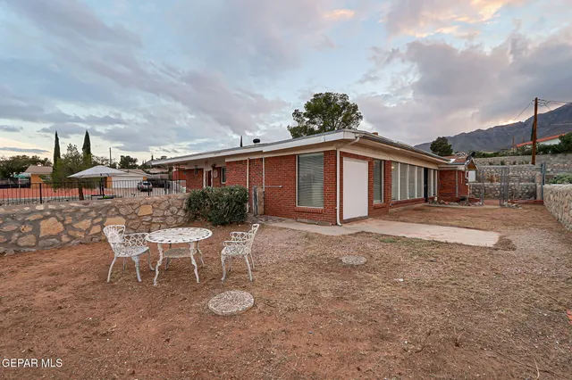 a view of a house with backyard and sitting area